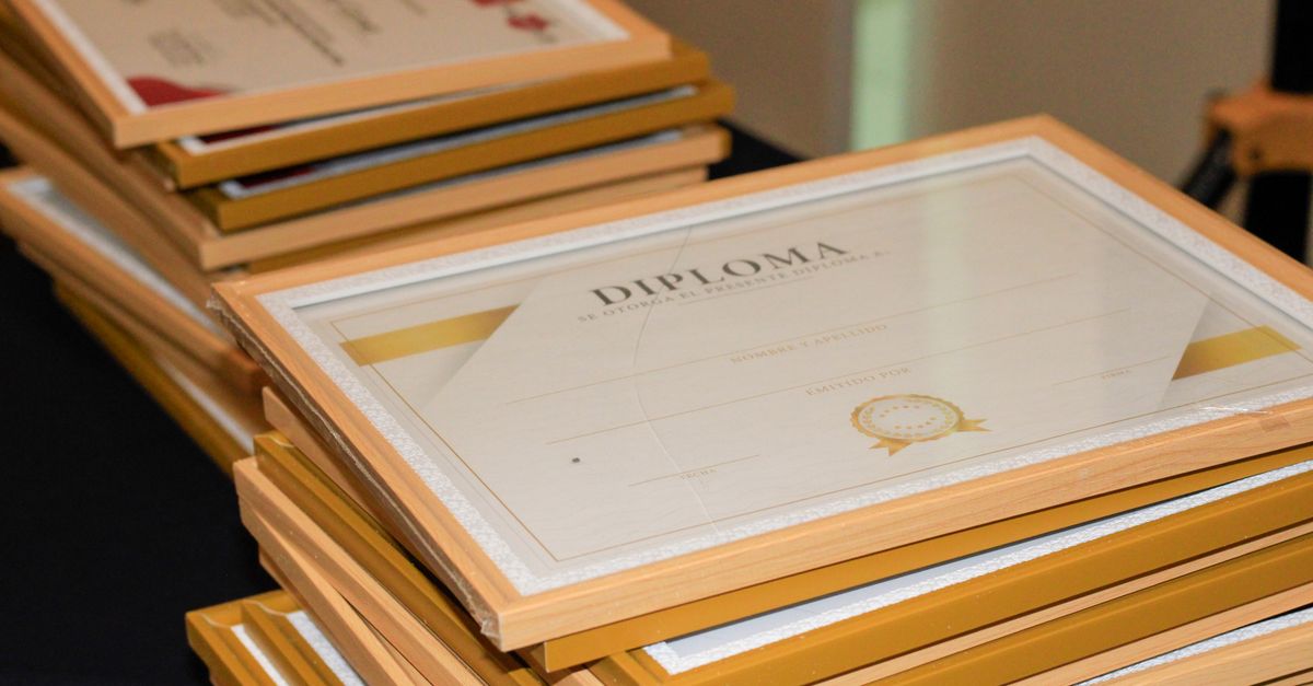 Diplôme de certification financière et manuel d'étude posés sur un bureau professionnel