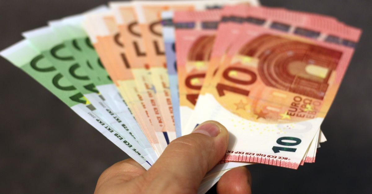 Billets de banque en euros et en dollars empilés, illustrant la monnaie fiduciaire moderne