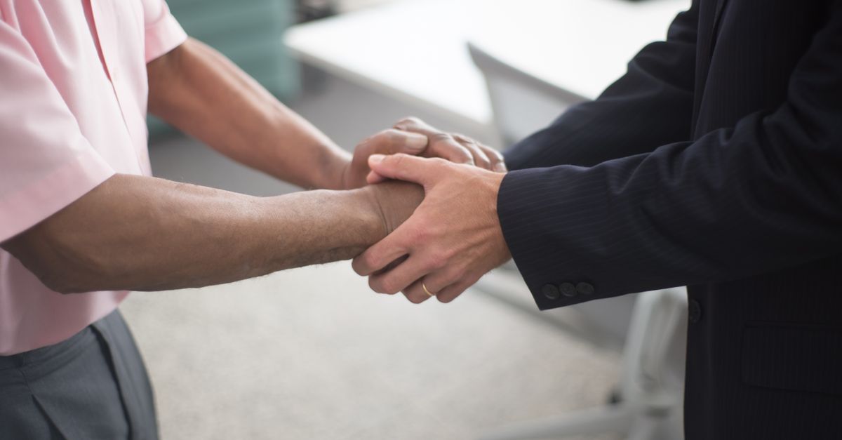 Deux dirigeants signant un contrat de fusion-acquisition dans une salle de réunion professionnelle