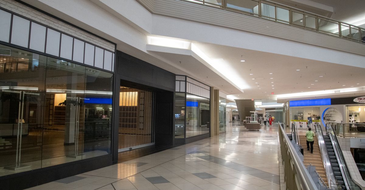 Centre commercial premium moderne avec verrière architecturale et boutiques de marques sur plusieurs niveaux