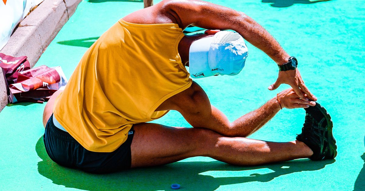 Personne réalisant un étirement des jambes en extérieur après une séance de course à pied