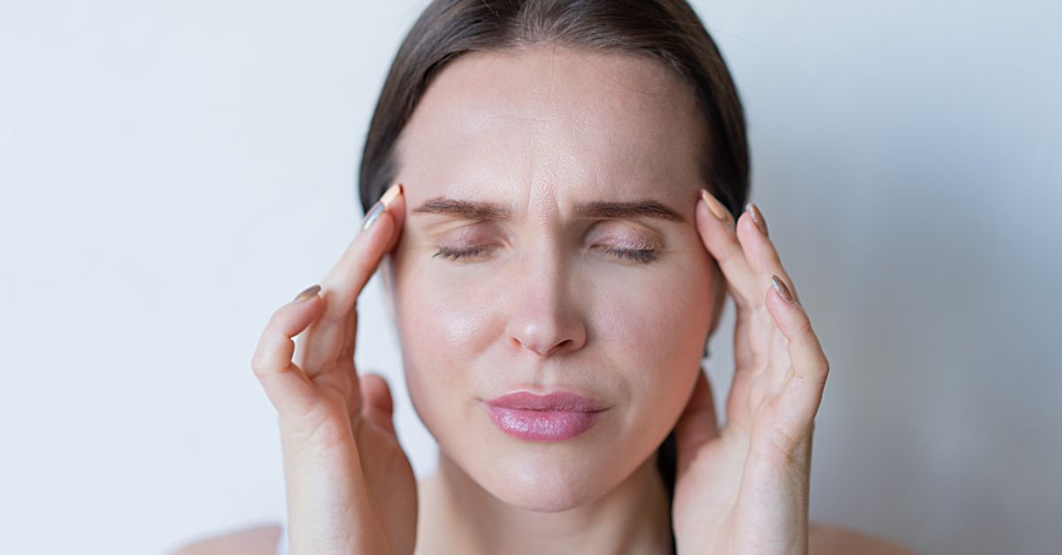 Femme se massant les tempes pour soulager un mal de tête