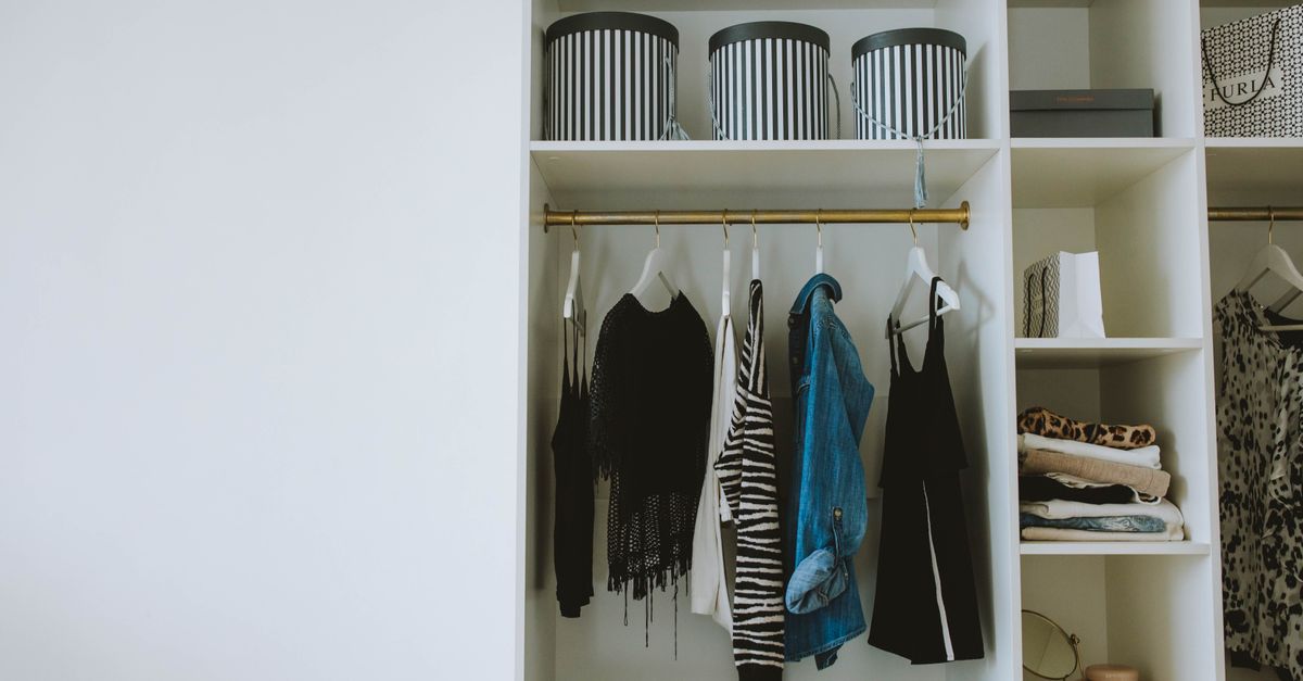 Dressing minimaliste rangé avec des vêtements neutres et polyvalents suspendus sur des cintres