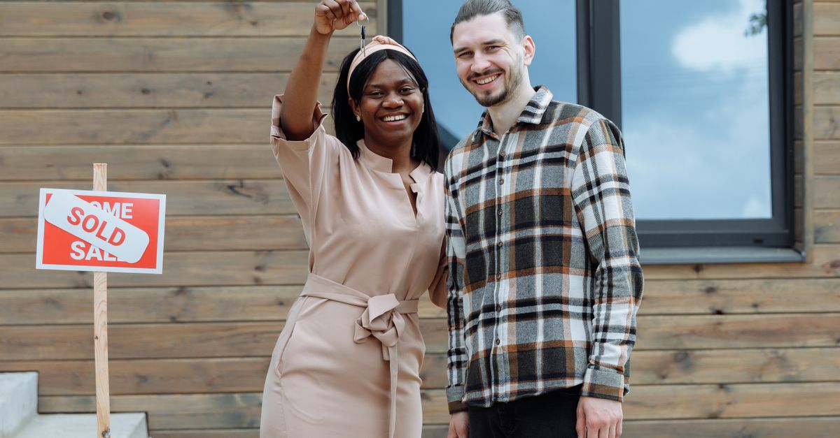 Jeune couple recevant les clés de sa première maison