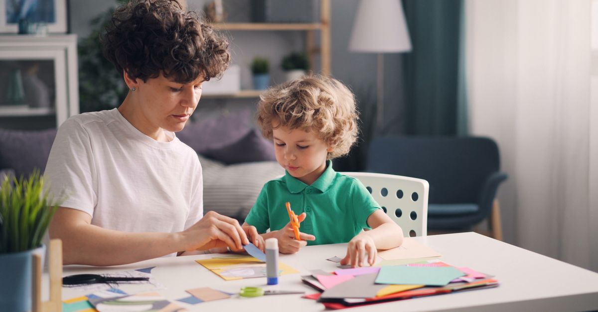 Enfant réalisant une activité manuelle à la table de la cuisine