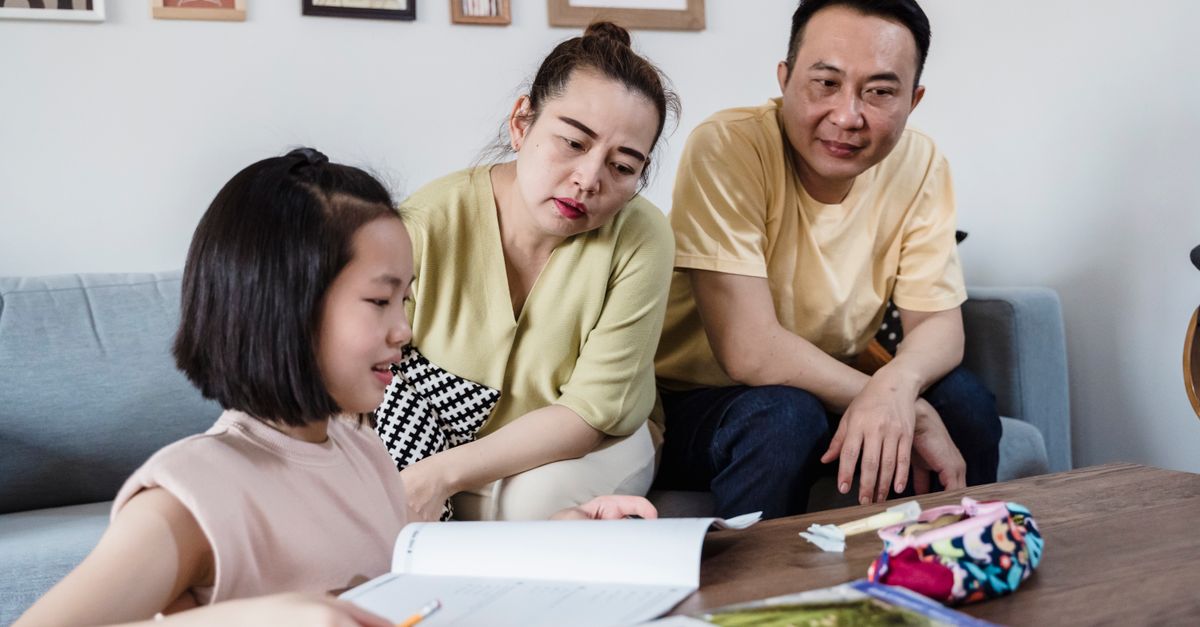 Enfant faisant ses devoirs à la maison avec un parent